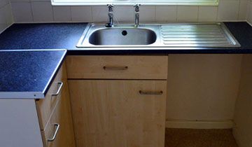 A bare sink cabinet