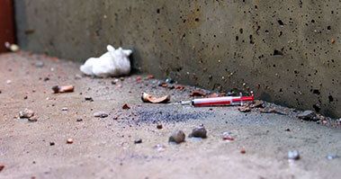 Broken objects including a syringe on the floor