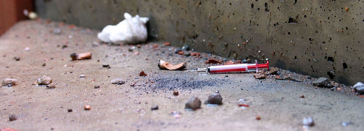 Broken objects on the floor including a syringe